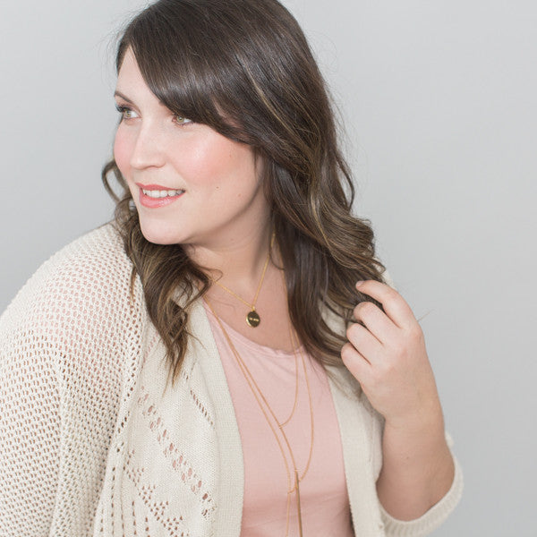 close up photo of brunette woman wearing inspirational necklace