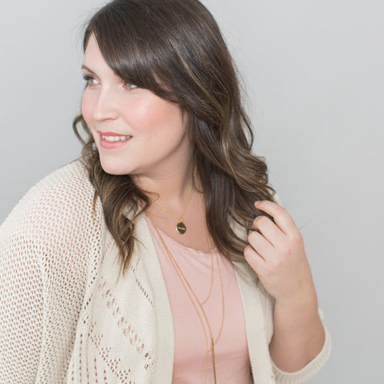 close up photo of brunette woman wearing inspirational necklace