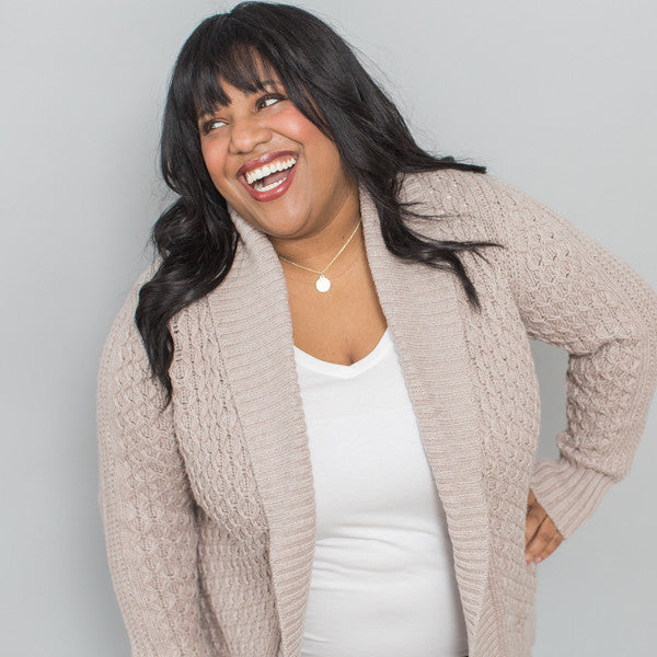 close up photo of woman laughing and wearing inspirational necklace
